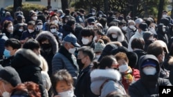 People line up to buy face masks to protect themselves from the new coronavirus outside Nonghyup Hanaro Mart in Seoul, South Korea, March 5, 2020. 
