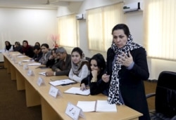 An Afghan woman speaks as they attend a class of the gender and women's studies masters program in Kabul University, Afghanistan on Oct. 19, 2015.