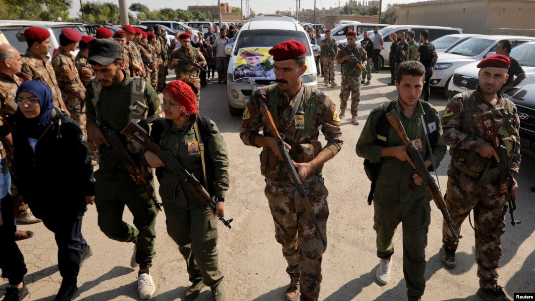 FILE - Fighters of Syrian Democratic Forces (SDF) take part in a funeral procession for comrades killed during clashes in the northeastern Syrian town of Ras al-Ayn, in the town of Qamishli, Syria, Oct, 22, 2019.