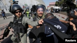 FILE - Israeli border policemen detain a Palestinian journalist during a protest to show solidarity with his colleague Muath Amarna, who was shot in his eye, in Bethlehem, in the Israeli-occupied West Bank, Nov. 17, 2019.