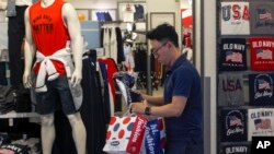 FILE - A man buys clothes from an American clothing store at a shopping mall in Beijing, China, July 15, 2019.