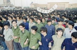 Chinese students link arms in solidarity at dawn on April 22, 1989 in Beijing’s Tiananmen Square