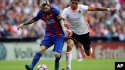 Enzo Perez de Valence, à droite, en duel avec Lionel Messi du FC Barcelone, à gauche, lors du match de football de la Liga espagnole entre Valence et le FC Barcelone au stade Mestalla à Valence, en Espagne, 22 octobre 2016. 