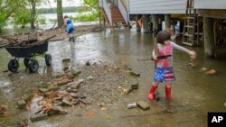 Devojčice čiste otpad sa poplavljene ulice na obali reke Misisipi u Nju Orleansu (Foto: AP/Matthew Hinton) 