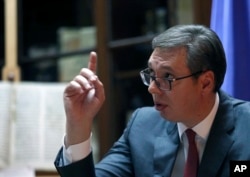 Serbian President Aleksandar Vucic speaks and gestures during an interview to The Associated Press, in Belgrade, Serbia, Oct. 13, 2017.