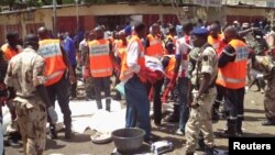 First responders gather at the site of a suicide bombing in N'djamena, Chad, where a man dressed in a woman's burqa blew himself up in the main market, killing 15 people and injuring 80, July 11, 2015.