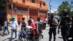 Residentes huyen de su casa en una motocicleta para evitar enfrentamientos entre bandas armadas en el barrio de La Plaine de Puerto Príncipe, Haití, el viernes 6 de mayo de 2022.