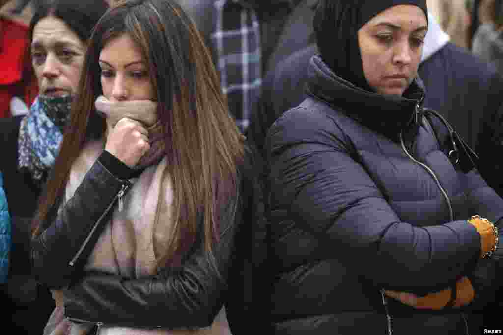 People observe a minute of silence at a street memorial to victims of Tuesday's bombings in Brussels, Belgium, March 24, 2016.