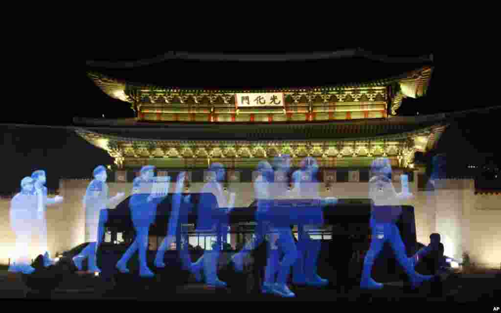 Hologram para demonstran ditampilkan di layar saat latihan demonstrasi holografik yang disebut &#39;protes hantu&#39;, menuntut kebebasan berkumpul dan menjamin hak untuk&nbsp; berkumpul dengan damai di depan Gwanghwamun, pintu utama Istana Gyeongbok Palace abad ke-14, salah satu tempat bersejarah Korea Selatan yang terkenal di one of South Korea&#39;s well known landmarks, in Seoul.