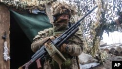 Un soldado ucraniano se ve en la línea de separación de los rebeldes prorrusos en la región de Donetsk, Ucrania, el lunes 10 de enero de 2022.
