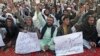 People hold signs as they chant slogans during a protest against satirical French weekly newspaper Charlie Hebdo, in Quetta, Pakistan, Jan. 15, 2015.