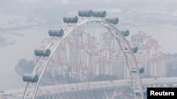 FILE - The Singapore Flyer observation wheel is shrouded by haze in this September, 2014 photo.
