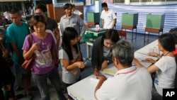 Thai voters wait in queue to cast ballot for the general election at a polling station in Bangkok, Thailand, Feb. 2, 2014. 