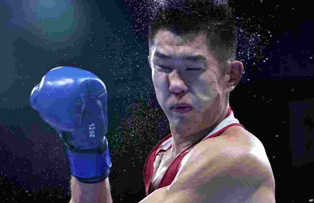 Russian Olympic Committee's Imam Khataev delivers a punch to Kazakhstan's Bekzad Nurdauletov during the men's light heavyweight 81-kg preliminaries boxing match at the 2020 Summer Olympics in Tokyo, Japan.