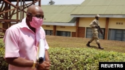 Paul Rusesabagina, retratado como un héroe en una película de Hollywood sobre el genocidio de Ruanda en 1994, es escoltado esposado desde la sala del tribunal en Kigali. Septiembre 25, 2021. Foto: Reuters.