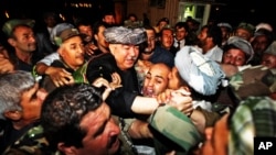 FILE - General Abdul Rashid Dostum, center in gray turban, leader of Afghanistan's Uzbek community arrives at the Kabul international airport, Aug. 16, 2009.