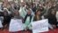 People hold signs as they chant slogans during a protest against satirical French weekly newspaper Charlie Hebdo, in Quetta, Pakistan, Jan. 15, 2015.