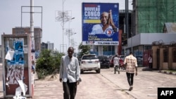 A man walks in front of a election banner for main opposition candidate Moïse Katumbi in Kinshasa on December 13, 2023. 