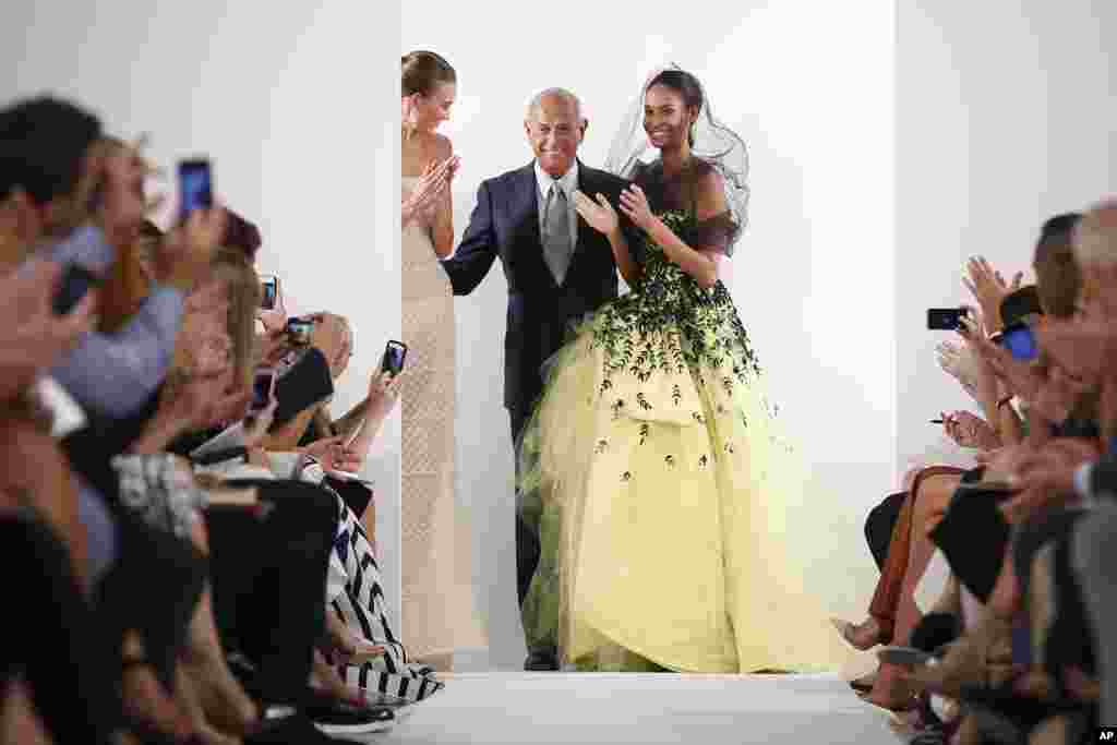 Designer Oscar de la Renta, center, greets the audience after his Spring 2014 collection was modeled during Fashion Week in New York, Tuesday, Sept. 10, 2013. (AP Photo/John Minchillo)