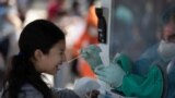 Una niña reacciona mientras le hacen la prueba de la enfermedad por coronavirus (COVID-19) en la Plaza El Salvador del Mundo en San Salvador, El Salvador, el 17 de enero de 2022.