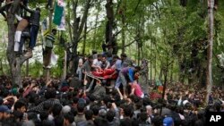 Penduduk Muslim Kashmir membawa mayat pemimpin pemberontak yang tewas terbunuh Saddam Padder, pada pemakamannya di desa Heff 65 kilometer sebelah selatan Srinagar, kawasan India yang dikuasai oleh Kashmir, 6 Mei 2018. 