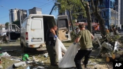 Trabajadores municipales trasladan el cuerpo de una persona fallecida tras el impacto de una bomba aérea rusa que mató al menos a tres personas e hirió a 23 en Járkov, Ucrania, el 22 de junio de 2024.