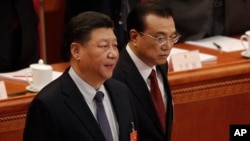 Chinese President Xi Jinping, left, and Chinese Premier Li Keqiang arrive at the opening session of China's National People's Congress at the Great Hall of the People in Beijing, Tuesday, March 5, 2019. 