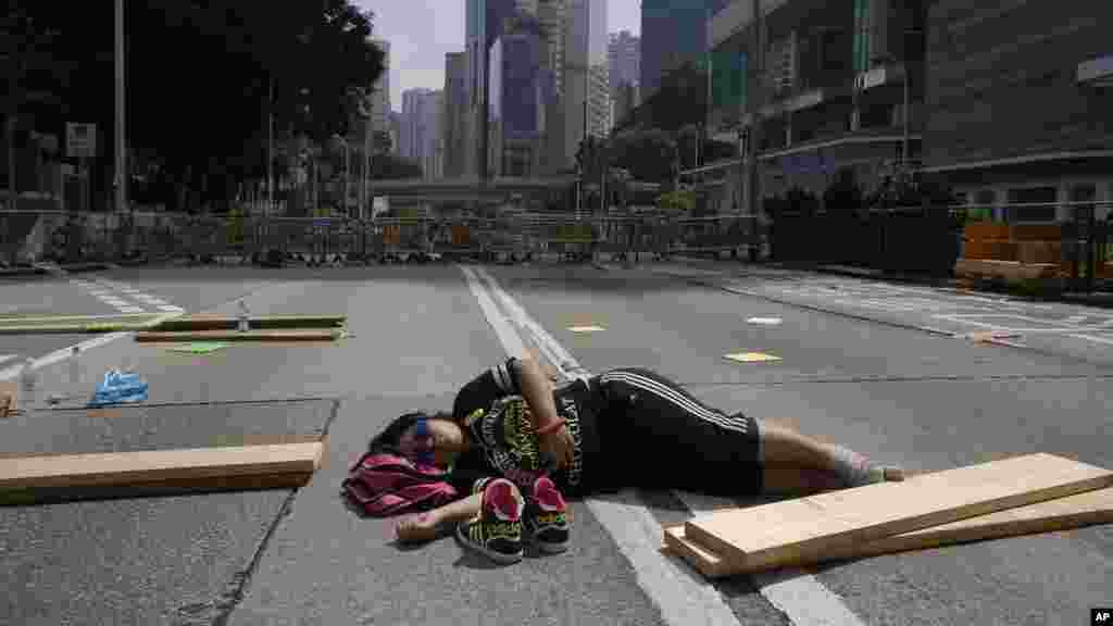 A lone pro-democracy student protester sleeps in the middle of an occupied road in Hong Kong, Oct. 5, 2014. 