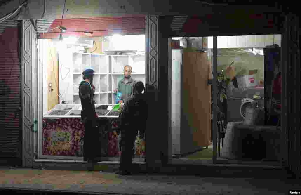Free Syrian Army fighters buy nuts from a shop in Deir al-Zor, April 7, 2013.