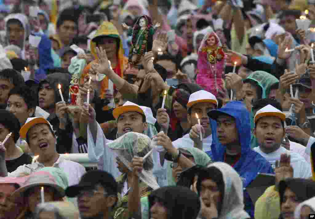 Filipinos hold lit candles to celebrate the Feast of the Santo Nino during a Mass officiated by Pope Francis at the Quirino Grandstand in Manila, Jan. 18, 2015.