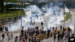 Pasukan keamanan menembakkan gas air mata ke arah demonstran anti pemerintah di Caracas, Venezuela, Rabu (19/4).