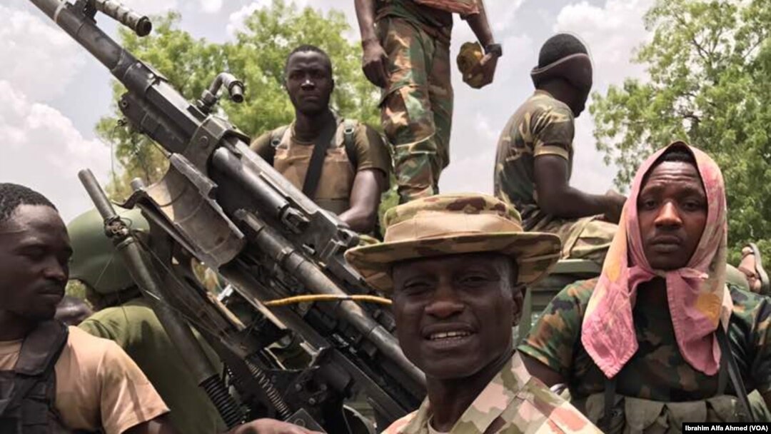 Sojojin Najeriya a tsaye kusa da wata mota mai dauke da bindiga da aka kwato daga hanun 'yan Boko Haram
