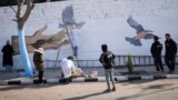 (FILE) A group of young volunteers paints a mural symbolizing peace on a wall on the outskirts of Damascus, Syria, Sunday, Jan. 12, 2025.