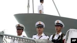 Chinese naval personnel stand at attention on the deck of the People's Liberation Army Navy's guided missile frigate FFG Zhoushan (file photo)
