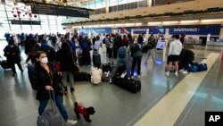 Holiday passengers departing Chicago's Midway International Airport check in, retrieve bag tags and head to the gates, Dec. 23, 2021.