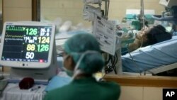 FILE - A hospital staffer monitors the vital signs of a suspected bird flu patient. Experts say the 3-D thread is a vast improvement over other biological diagnostic devices.