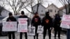 ARCHIVO - Activistas de Revcom Corps Chicago sostienen carteles afuera de la escuela primaria Hamline después de que agentes federales fueron rechazados el 24 de enero de 2025 en Chicago.