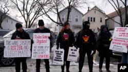 ARCHIVO - Activistas de Revcom Corps Chicago sostienen carteles afuera de la escuela primaria Hamline después de que agentes federales fueron rechazados el 24 de enero de 2025 en Chicago.