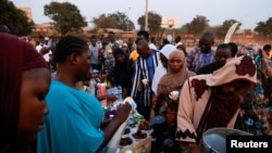 Musulmans et chrétiens burkinabè se rassemblent pour rompre le jeûne ensemble dans l'espoir de promouvoir la tolérance religieuse pendant le Ramadan sur la place publique de Ouagadougou, au Burkina Faso, le 31 mars 2023.