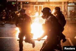 Polisi Portland menghindari koktail molotov selama kerusuhan yang mengikuti keputusan dewan juri dalam kasus Breonna Taylor Louisville, di Portland, Oregon, AS, 23 September 2020.