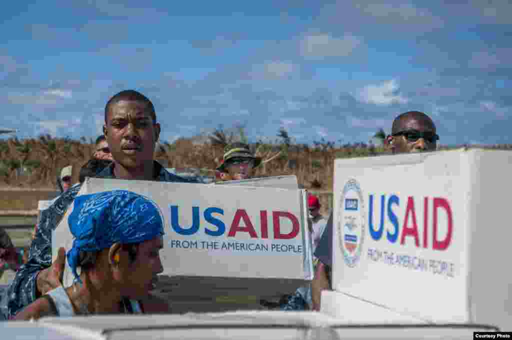 Hospital Corpsman Quinton Dotson, from the U.S. Navy's forward-deployed aircraft carrier USS George Washington (CVN 73), from Reno, Nev., left, and other U.S. military personnel and Philippine citizens unload relief supplies in support of Operation Damaya