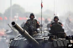 FILE - Myanmar military tanks are driven during a parade to commemorate the nation's 72nd Armed Forces Day in Naypyitaw, March 27, 2017.