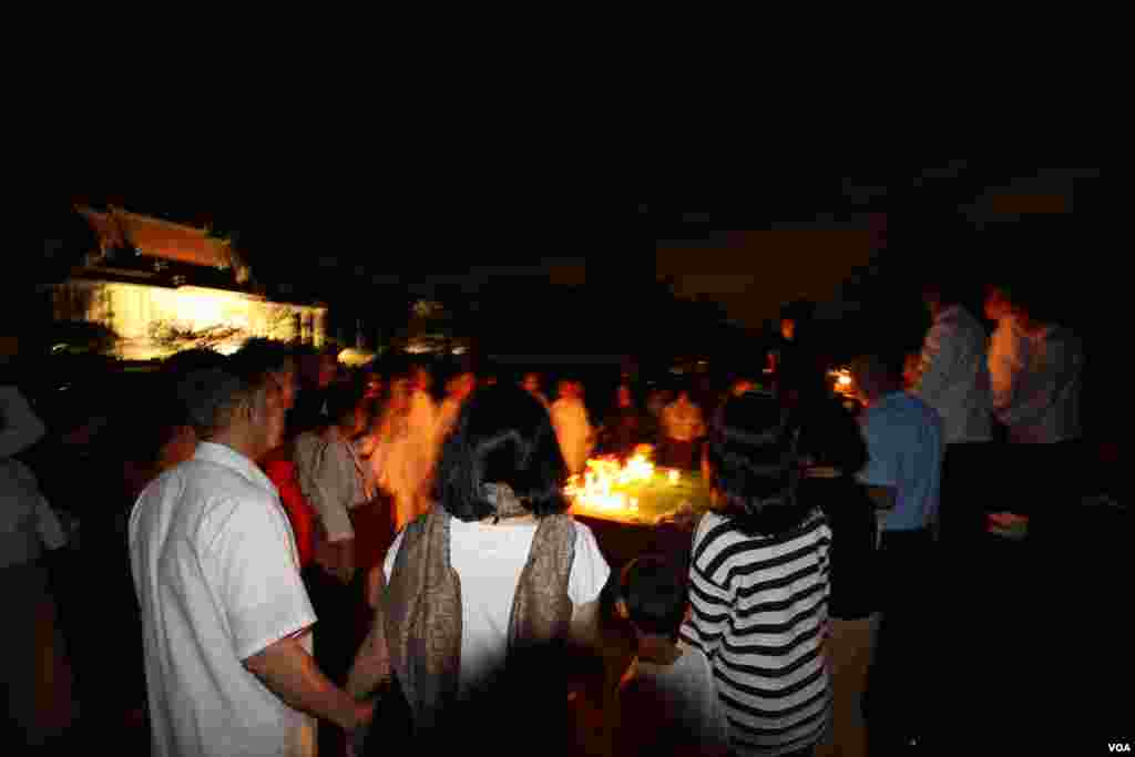 Cambodian-Americans hold hands around candles at a candle vigil during a memorial service for Khmer Rouge victims at the Wat Buddhikaram Cambodian Buddhist temple in Silver Spring, Maryland, to mark the 40th anniversary of the takeover of the Khmer Rouge, on Friday, April 17, 2015. (Sophat Soeung/VOA Khmer)