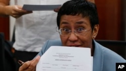 Wartawan Maria Ressa, menunjukkan surat perintah penangkapan dirinya dari Biro Penyidik Federal Filipina, hari Rabu (13/2).