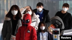 FILE - Passengers wearing masks to prevent a new coronavirus arrive at Incheon International Airport in Incheon, South Korea, Jan. 29, 2020. 