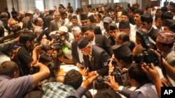 FILE - Communist Party of Nepal (Unified Marxist–Leninist), leader K.P. Oli, center, signs the constitution document in the Constituent Assembly hall in Kathmandu, Nepal, Sept. 18, 2015. 