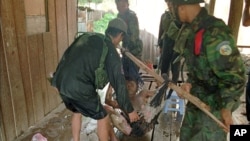 An unidentified injured soldier is helped in a make-shift stretcher by his comrades after a tank he was riding was hit by a rocket Sunday, July 6, 1997, in fighting between Second Premier Hun Sen and Prince Ranarridh's armies, Phnom Penh, Cambodia. 