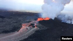 FILE - A cinder-and-spatter cone is building at fissure 8 as the cone continues to feed a lava flow that reaches the ocean at Kapoho during ongoing eruptions of the Kilauea Volcano in Hawaii, June 11, 2018. Next week, a major hurricane could brush by the 