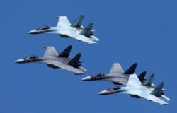 FILE - Sukhoi Su-35 jet fighters of the "Sokoly Rossii" (Falcons of Russia) aerobatic team fly in formation during a rehearsal for the airshow in Krasnoyarsk, Russia, Aug. 1, 2019.