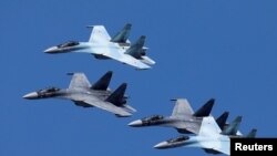 FILE - Sukhoi Su-35 jet fighters of the "Sokoly Rossii" (Falcons of Russia) aerobatic team fly in formation during a rehearsal for the airshow in Krasnoyarsk, Russia, Aug. 1, 2019.